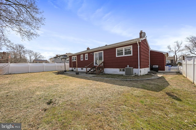 back of house with entry steps, a fenced backyard, central air condition unit, a lawn, and a chimney