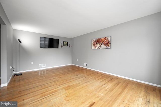 spare room featuring baseboards, visible vents, and hardwood / wood-style floors