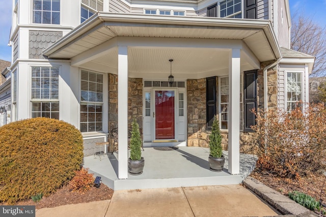 entrance to property with stone siding and a porch