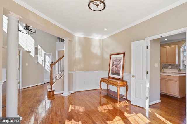 interior space with light wood-type flooring, decorative columns, and stairs