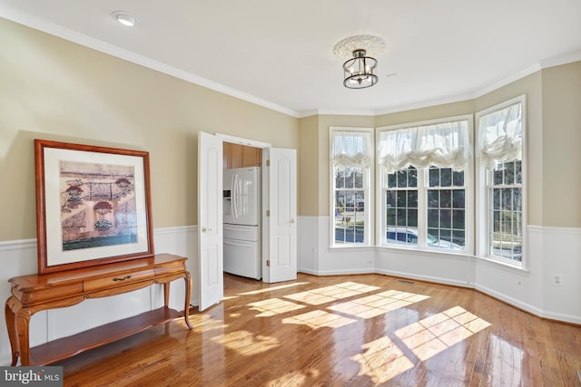 interior space with a chandelier, ornamental molding, wood finished floors, and baseboards