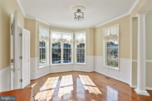 unfurnished sunroom with visible vents and decorative columns