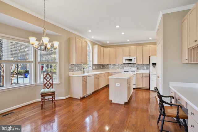 kitchen with light countertops, white appliances, visible vents, and wood finished floors