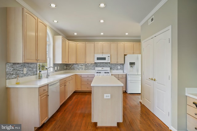 kitchen with white appliances, visible vents, crown molding, light brown cabinets, and a sink