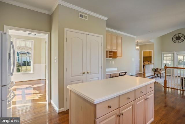 kitchen with dark wood-type flooring, freestanding refrigerator, visible vents, and light brown cabinetry