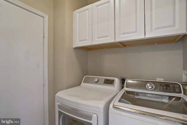 laundry area featuring washer and clothes dryer and cabinet space