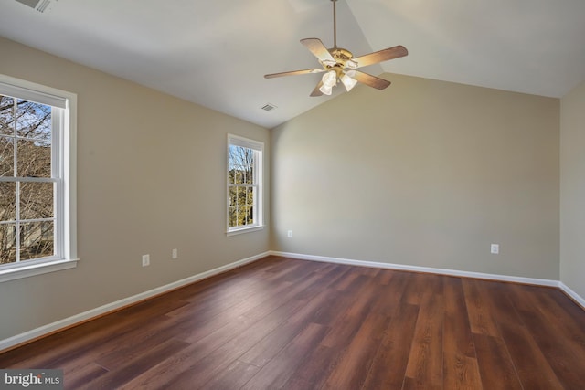 spare room with lofted ceiling, visible vents, dark wood-type flooring, ceiling fan, and baseboards