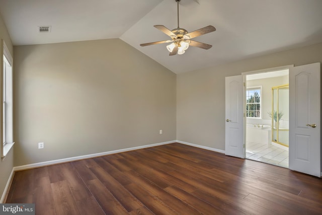 spare room featuring ceiling fan, wood finished floors, visible vents, baseboards, and vaulted ceiling