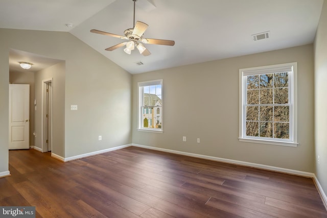 spare room with visible vents, dark wood-type flooring, vaulted ceiling, ceiling fan, and baseboards