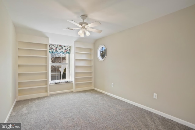 carpeted spare room with a ceiling fan and baseboards