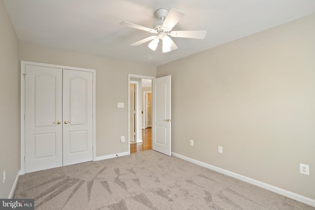 unfurnished bedroom featuring a closet, carpet, a ceiling fan, and baseboards