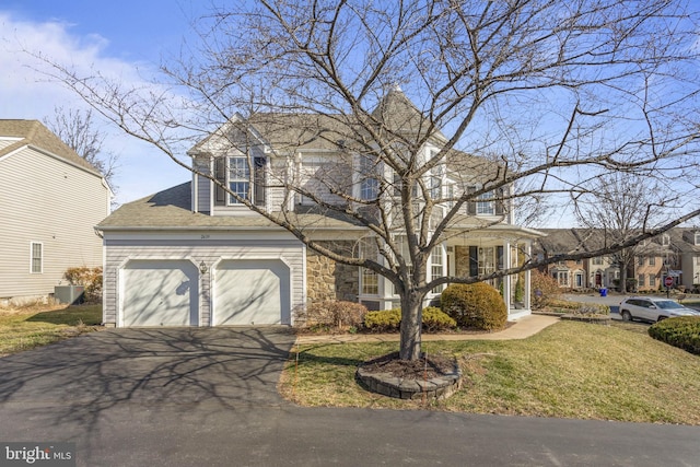 view of front facade with a shingled roof, cooling unit, stone siding, driveway, and a front lawn