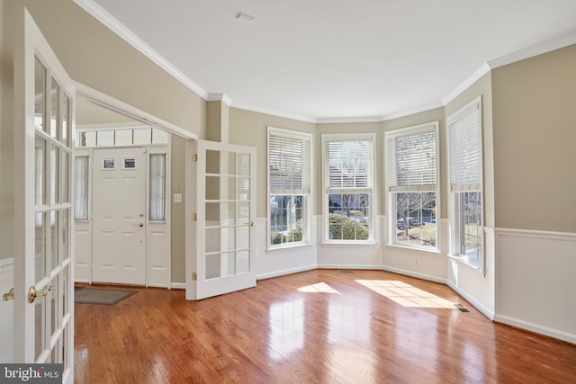 unfurnished sunroom with a healthy amount of sunlight, visible vents, and french doors