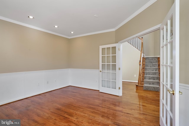 spare room with french doors, wainscoting, stairway, and wood finished floors