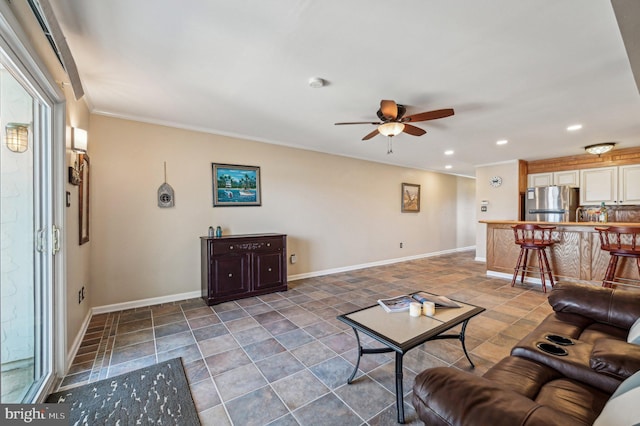 living room with recessed lighting, a ceiling fan, crown molding, and baseboards