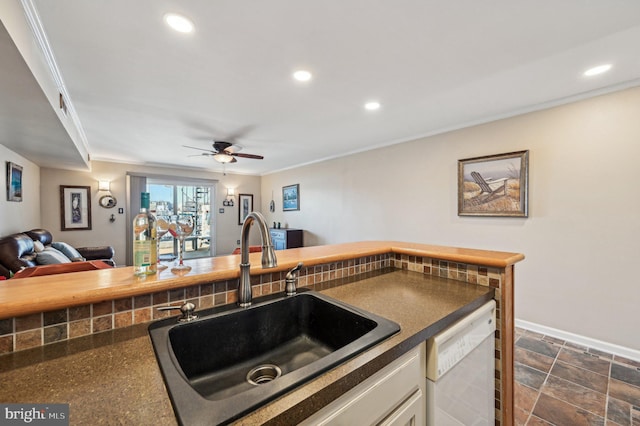 kitchen featuring dark countertops, a sink, recessed lighting, and white dishwasher