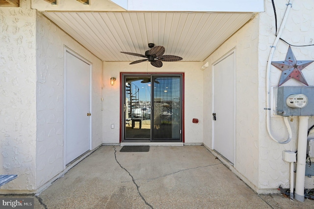 property entrance featuring stucco siding, a ceiling fan, and a patio area