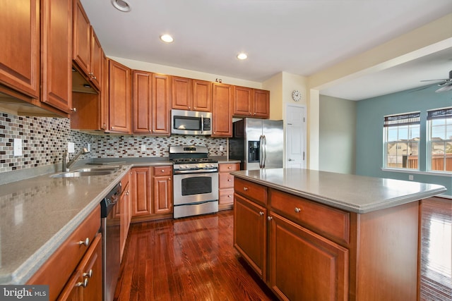 kitchen with a sink, backsplash, brown cabinetry, stainless steel appliances, and dark wood-style flooring