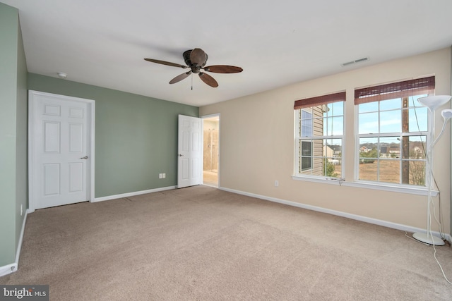 unfurnished bedroom with baseboards, visible vents, carpet floors, and ceiling fan