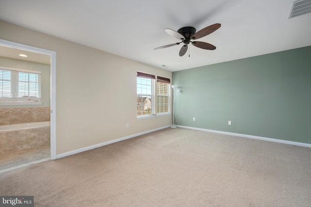 spare room with carpet, visible vents, a wealth of natural light, and baseboards