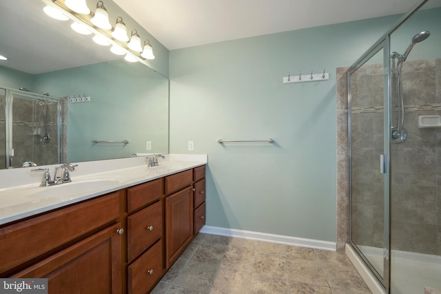 bathroom featuring double vanity, baseboards, a stall shower, and a sink