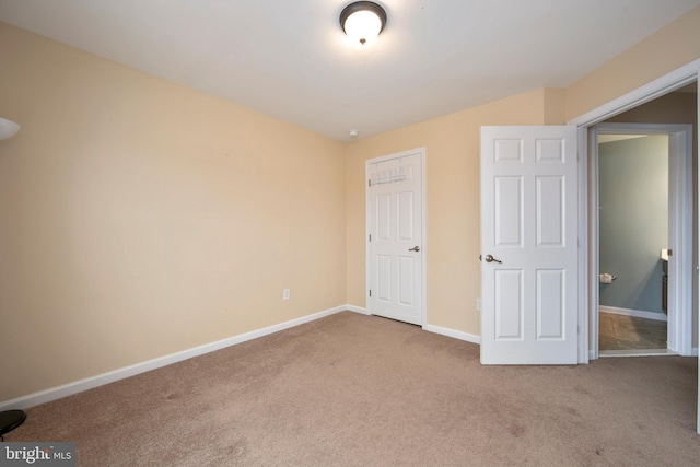 unfurnished bedroom with baseboards and carpet