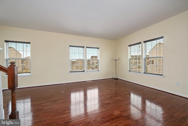 empty room with a healthy amount of sunlight, baseboards, and hardwood / wood-style flooring