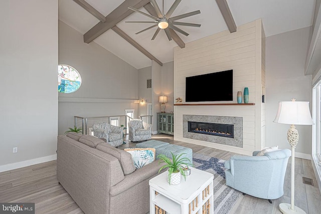 living area with high vaulted ceiling, beam ceiling, baseboards, and wood finished floors