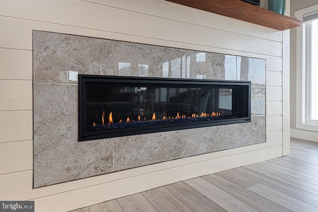 room details with wood finished floors and a glass covered fireplace