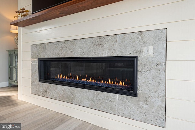 details featuring a fireplace and wood finished floors