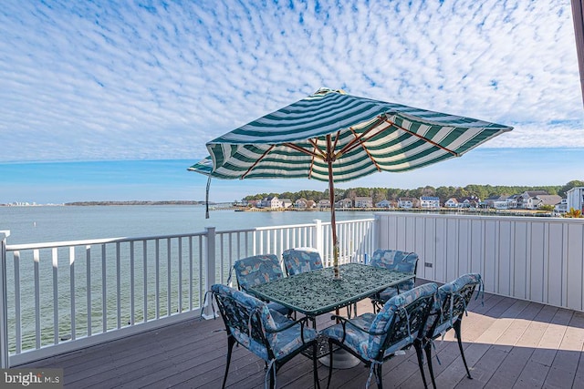 wooden terrace featuring outdoor dining space and a water view