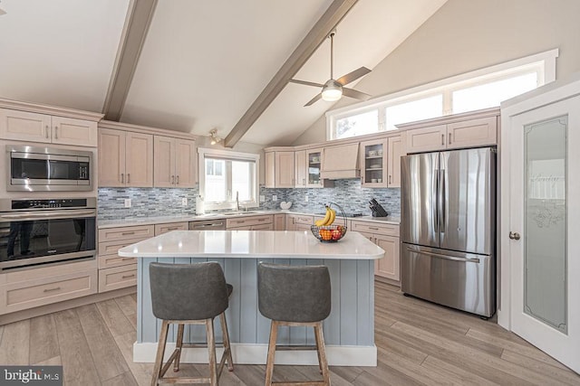 kitchen with stainless steel appliances, light wood-type flooring, light countertops, and a breakfast bar area