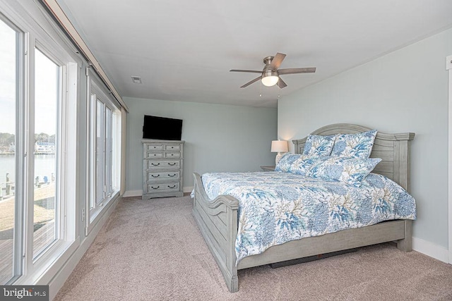 bedroom featuring light carpet, ceiling fan, and baseboards