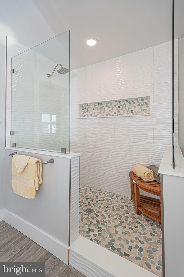 bathroom with a walk in shower and wood finished floors