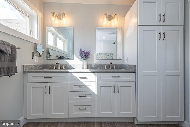 full bath with double vanity, a shower, and a sink