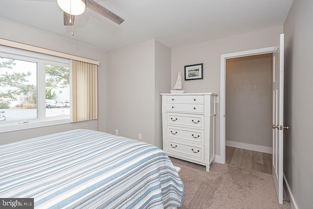 bedroom featuring a ceiling fan, light colored carpet, and baseboards