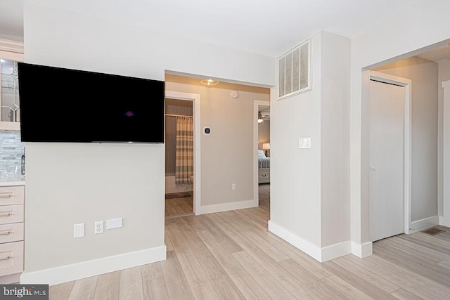 interior space featuring light wood finished floors, visible vents, and baseboards