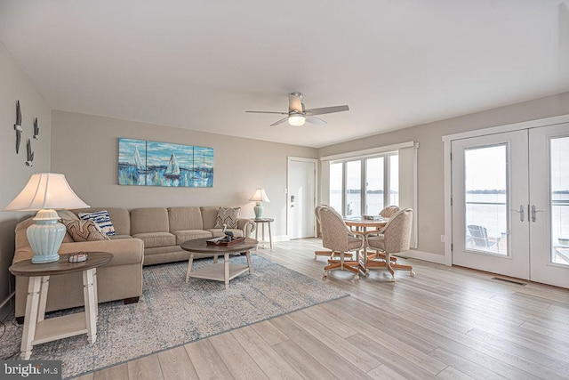 living room with baseboards, a ceiling fan, wood finished floors, and french doors