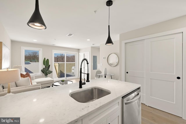 kitchen with visible vents, hanging light fixtures, a sink, white cabinetry, and stainless steel dishwasher