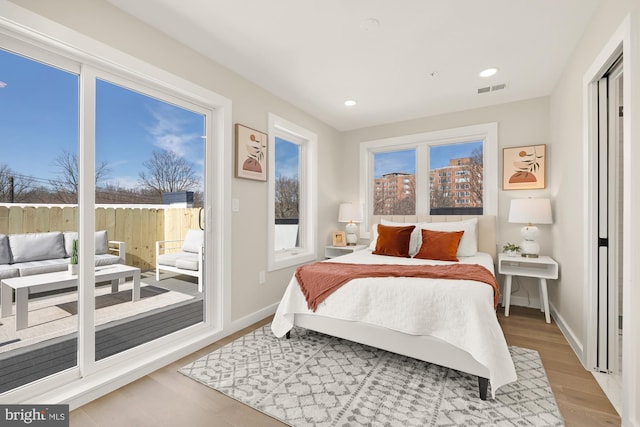 bedroom featuring recessed lighting, visible vents, wood finished floors, access to outside, and baseboards