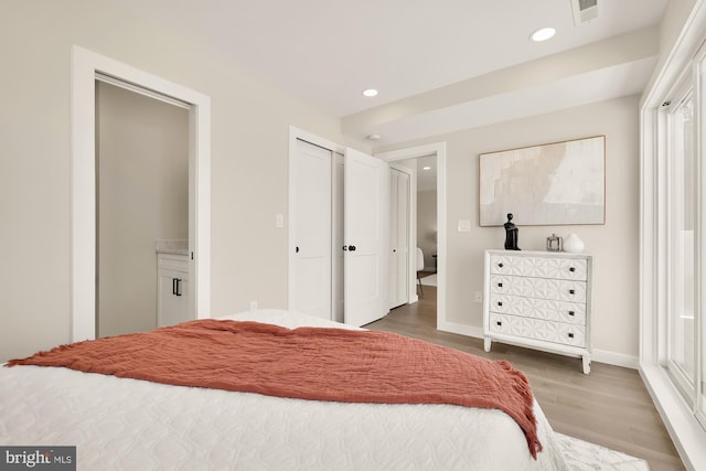 bedroom with baseboards, visible vents, wood finished floors, and recessed lighting