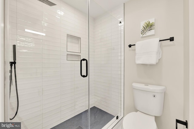 full bathroom featuring a stall shower and toilet