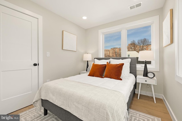 bedroom featuring light wood-style floors, baseboards, visible vents, and recessed lighting