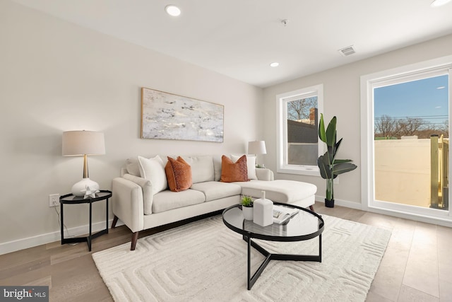 living area with baseboards, recessed lighting, visible vents, and light wood-style floors