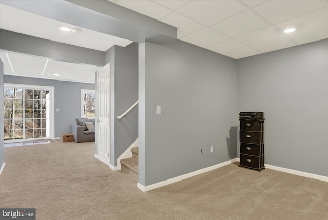 below grade area with a drop ceiling, recessed lighting, stairway, carpet flooring, and baseboards