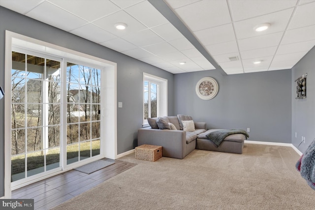 carpeted living room featuring recessed lighting, visible vents, baseboards, and a drop ceiling