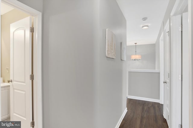 hall featuring baseboards and dark wood-type flooring