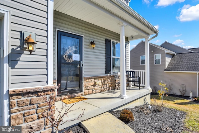 property entrance featuring stone siding and a porch