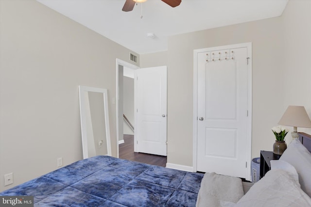 bedroom with visible vents, baseboards, wood finished floors, and a ceiling fan