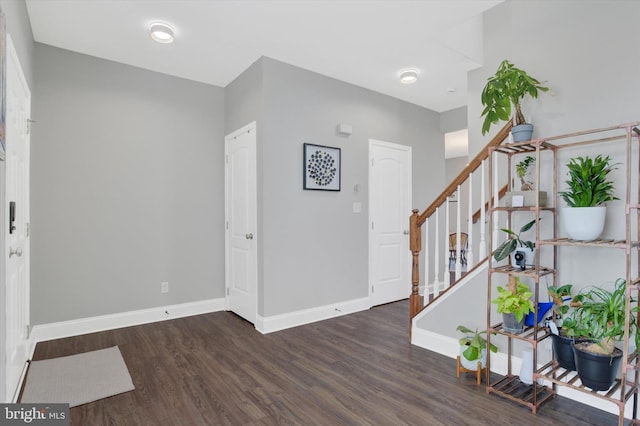 foyer featuring stairway, wood finished floors, and baseboards